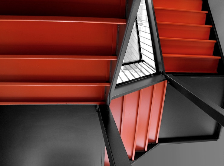 Free Photo orange staircases of a building next to a mirror