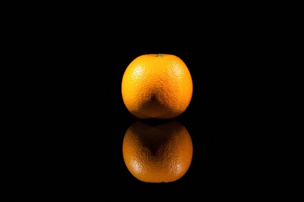 The orange stands on the black background