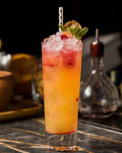 orange strawberry cocktail with shaved ice, garnished with dried orange