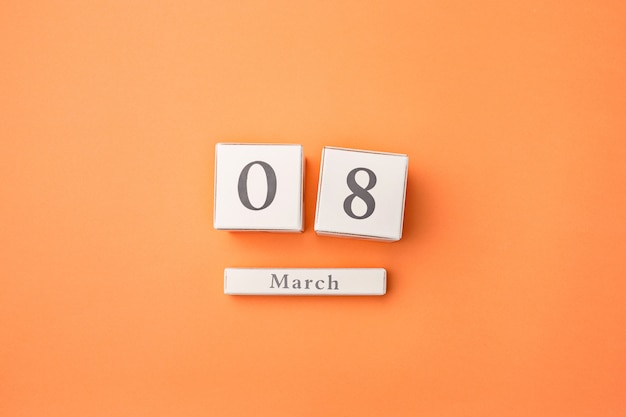 Free photo orange table with wooden calendar