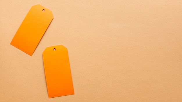 Orange tags on neutral carboard sheet with copy space