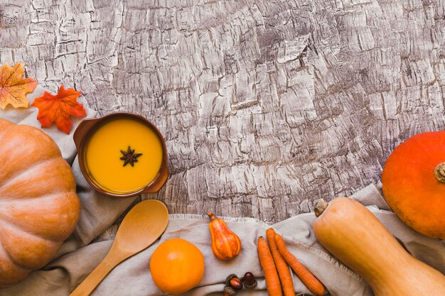 Оранжевые овощи и фрукты возле супа