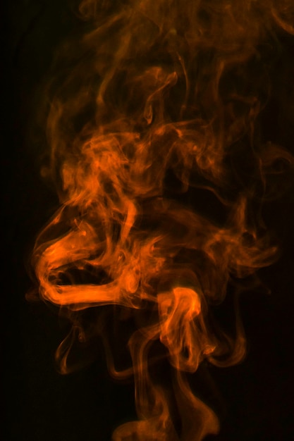 An orange wispy smoke spread over a black background