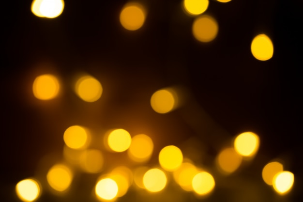 橙色の黄色の明るいボケ灯。美しいクリスマスの背景。