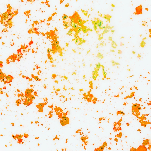 Free photo an orange and yellow color powder on white background
