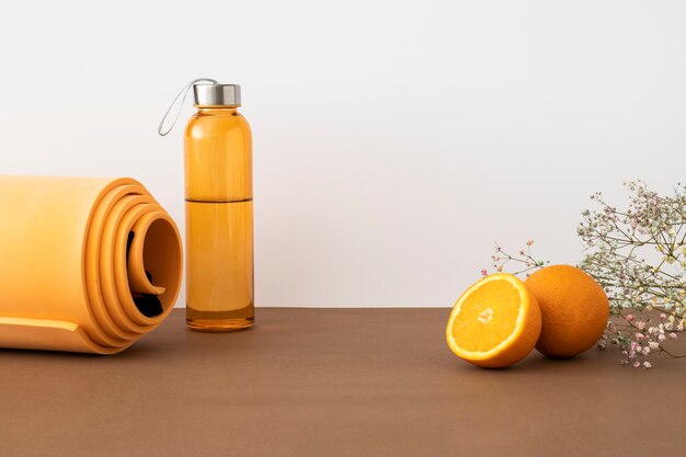 オレンジ色のヨガマットとウォーターボトルのアレンジメント