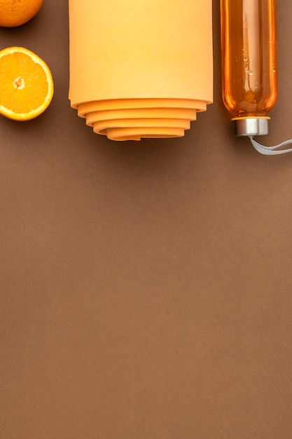 オレンジ色のヨガマットとウォーターボトルの上面図