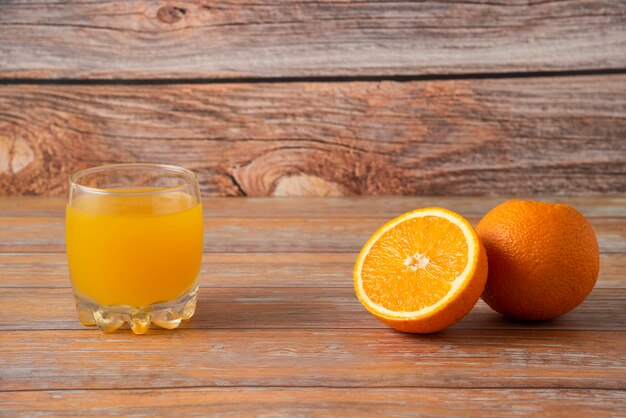 오렌지와 나무에 고립 된 주스 한 잔