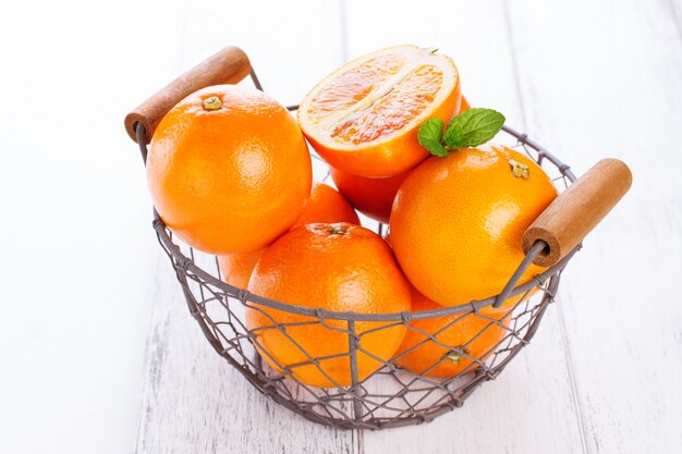 Апельсины в металлической корзине