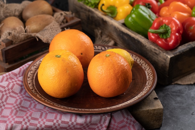 Oranges in a platter and peppers around
