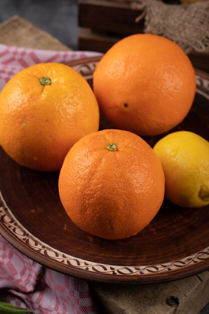 Апельсины в гончарном блюде.