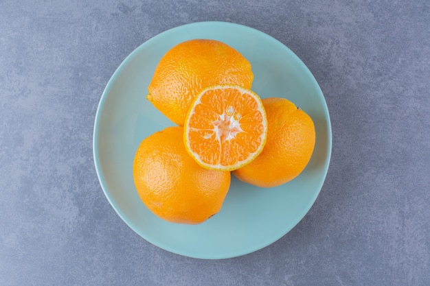 플래튼 대리석 테이블에 오렌지가 서로 겹쳐져 있습니다.