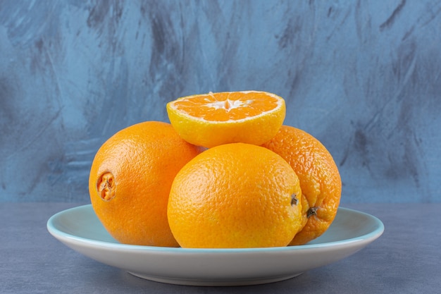 プラトン大理石のテーブルの上にオレンジが積み重なっています。