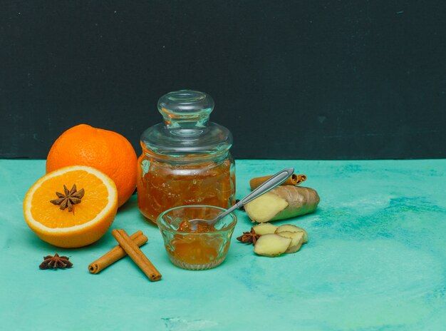 テクスチャーと暗いシアンのソーサー、生姜、スライス側面図でジャムとオレンジ