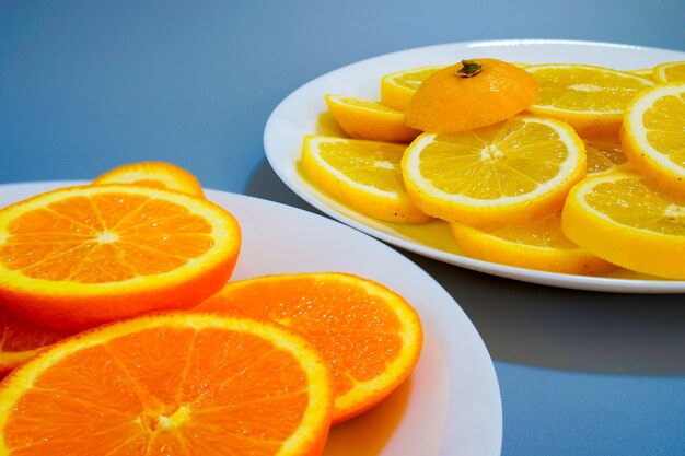 Oranges and yellow lemons on a plate on a sunny day