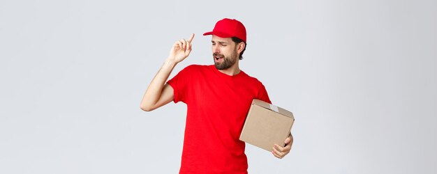 Order delivery online shopping and package shipping concept carefree handsome bearded courier in red...