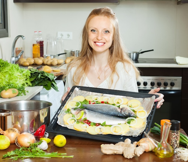 Free photo ordinary housewife cooking fish  in sheet pan