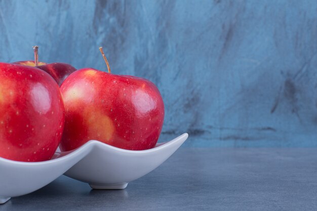 대리석 테이블에 접시에 유기농 사과입니다.