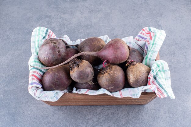 Organic beetroots on a wooden platter isolated on grey concrete background.