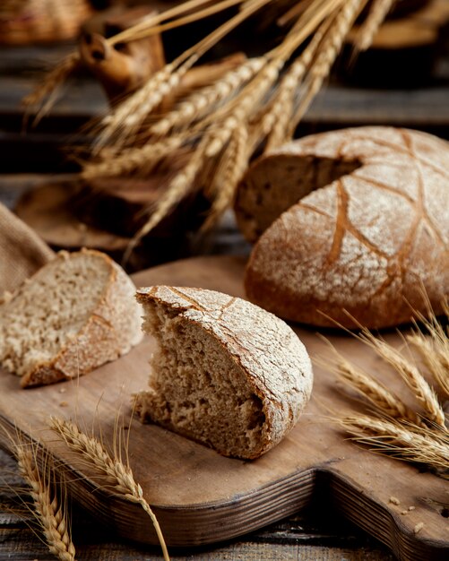 Organic brown bread slice placed on wooden board in rustic style