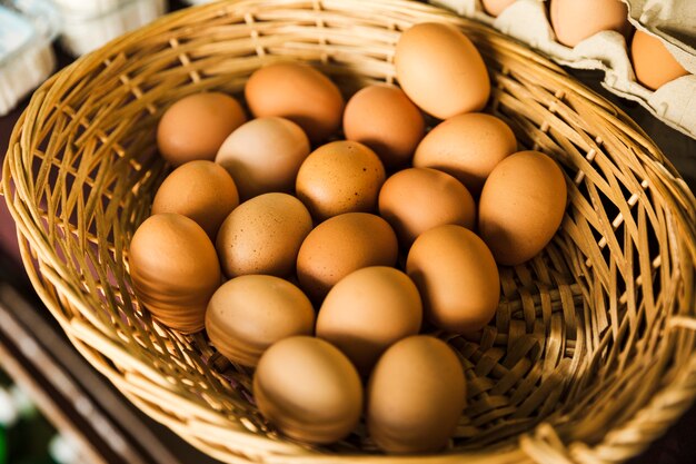 Органическое коричневое яйцо в плетеной корзине в супермаркете