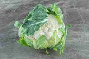 Free photo organic cauliflower. cloe up photo of green cauliflower on grey table.