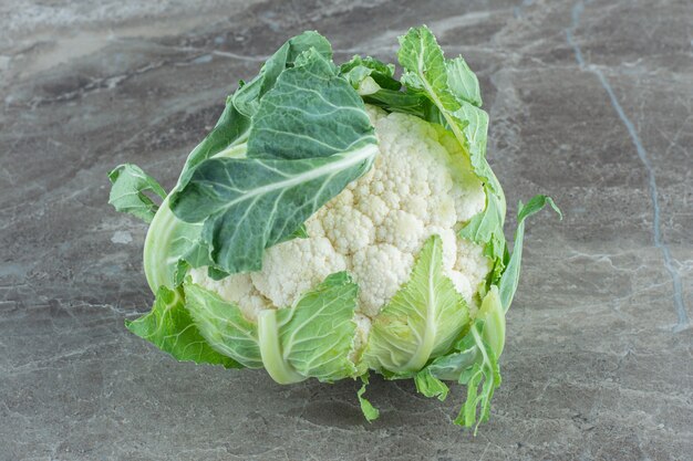 Organic cauliflower. Cloe up photo of green cauliflower on grey table.