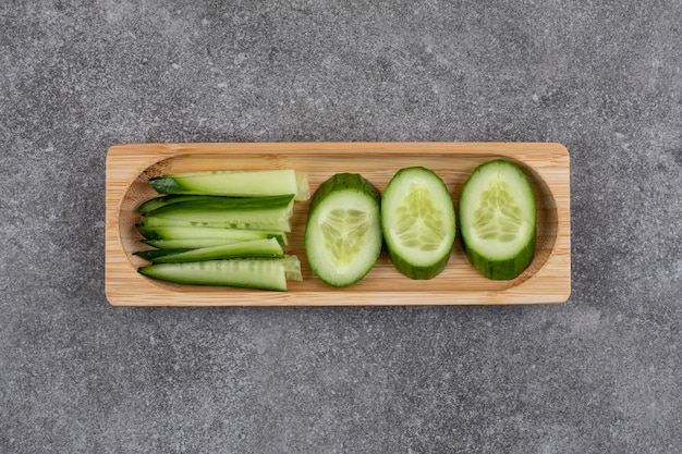Free photo organic cucumber slices on wooden board