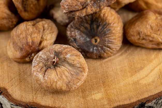 Organic dried figs on wood piece. 