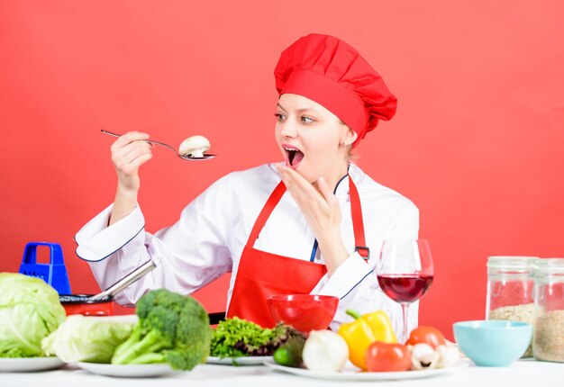 Organic eating and vegetarian. housewife. surprised woman cooking healthy food by recipe. woman in cook hat. professional chef on red background. restaurant menu. dieting. cook delicious recipe.