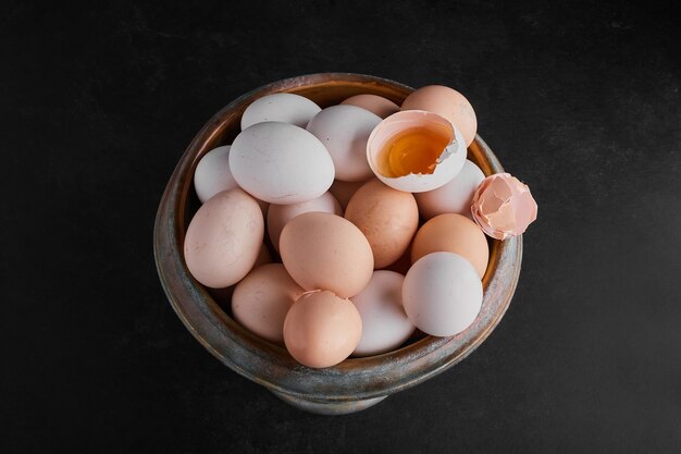 Organic eggs and eggshells in a metallic bowl. 