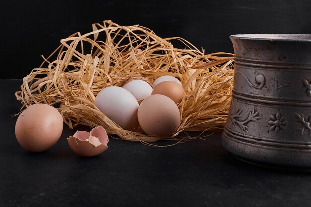 Organic eggs in the nest on black space. 