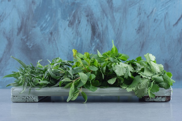 Organic fresh greens on wooden board . 