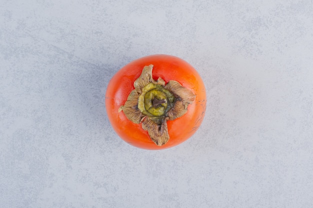 Organic fresh orange persimmon on grey background. 