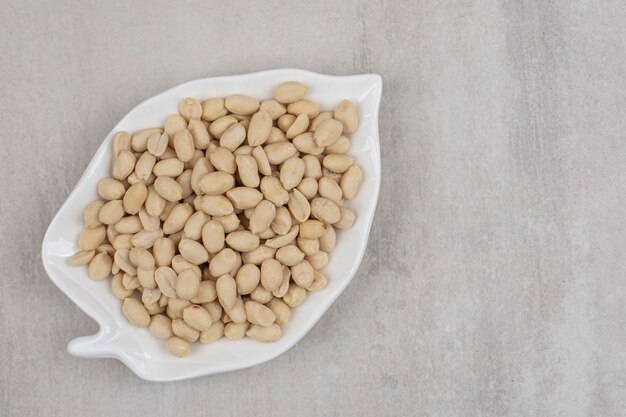 Organic fresh peanuts on leaf shaped plate.