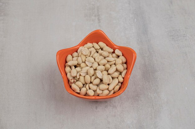 Organic fresh peanuts in orange bowl.