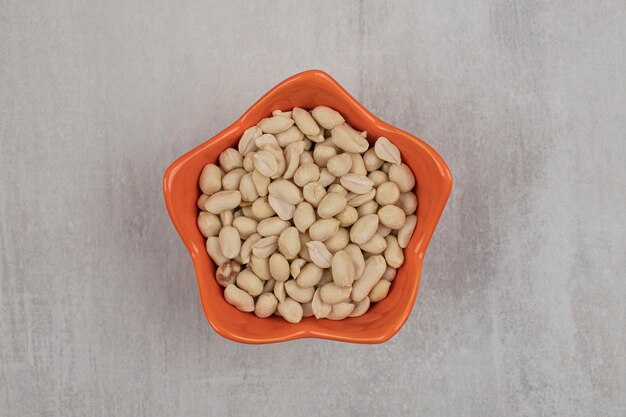 Organic fresh peanuts in orange bowl.
