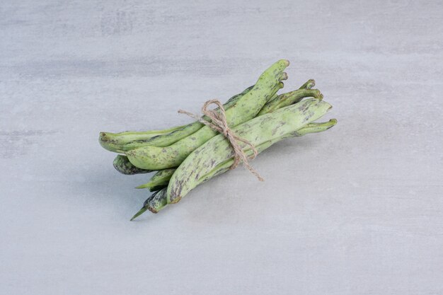 Organic green beans tied with rope on stone surface. High quality photo