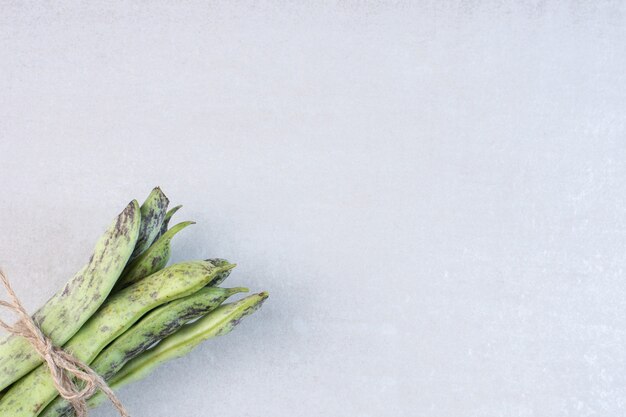 Organic green beans tied with rope on stone surface. High quality photo