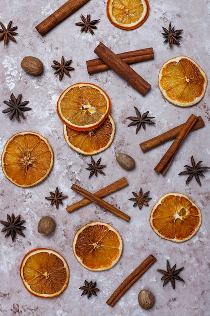 Organic homemade dried orange chips slices,nuts,star anise,cinnamon sticks on light brown surface