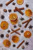 Бесплатное фото Органические домашние сушеные ломтики апельсиновых чипсов, орехи, анис, палочки корицы на светло-коричневой поверхности
