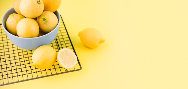 Foto gratuita limoni organici in una ciotola con lo spazio della copia