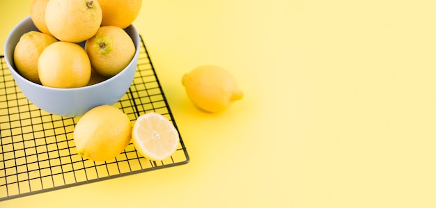 Органические лимоны в миску с копией пространства