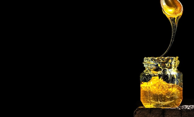 ガラスの瓶の中の明るい日光に照らされた有機天然蜂蜜