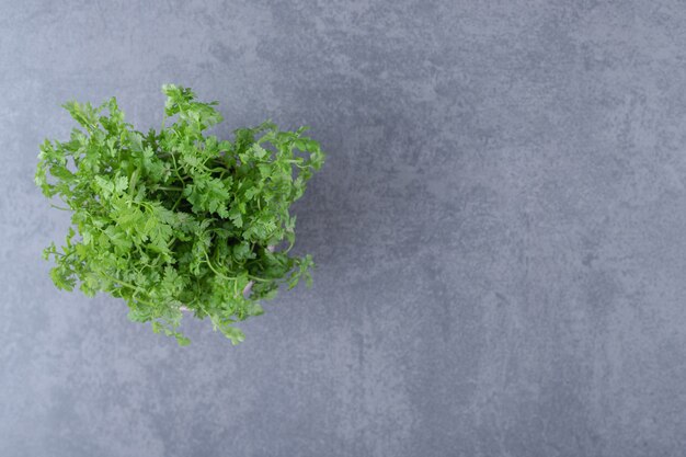 Organic parsley in the bowl, on the marble surface.
