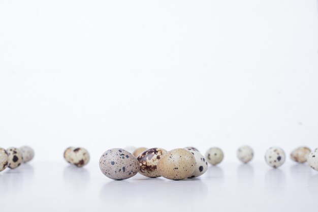 Organic quail eggs on white surface.