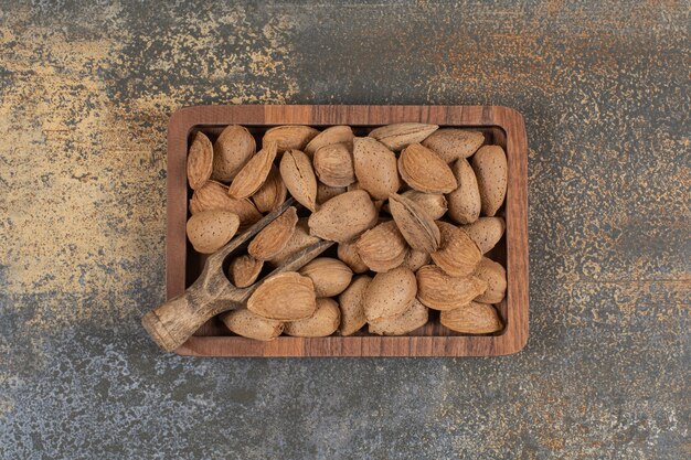 Organic shelled almonds on wooden plate. 