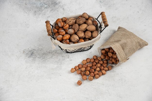 Organic shelled hazelnut and walnuts in basket with sackcloth of kernels. 