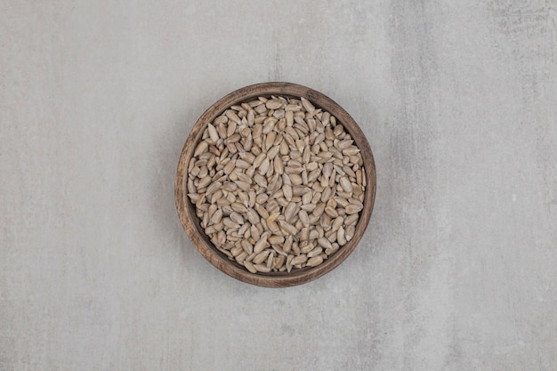 Organic sunflower seeds in wooden bowl.