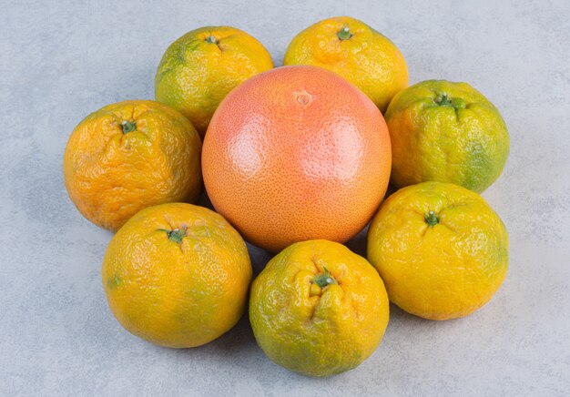 Organic Tangerines (oranges, clementines, citrus fruits) over grey background . 